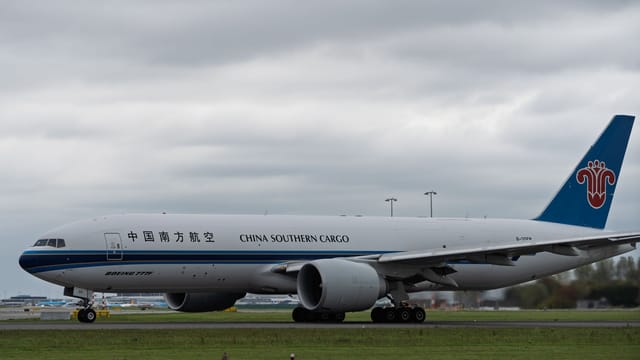 China Southern Cargo Boeing 777 aircraft taxiing on runway under cloudy skies.