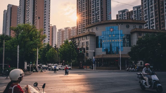 A bustling city intersection at sunset, highlighting urban life among towering skyscrapers.