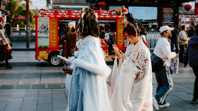 People in traditional attire on a vibrant street in Nanjing, capturing a moment of Chinese culture.