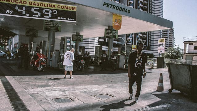 Stylish youth at a Petrobras gas station in a bustling urban setting.