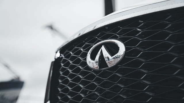 Detailed view of a luxury vehicle's grille featuring intricate design and logo.
