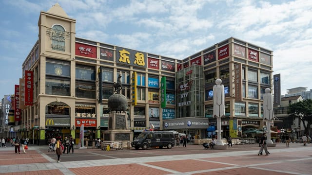 A vibrant commercial square in Guangzhou showcasing modern architecture and lively urban scene.