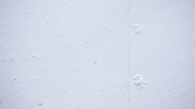 Textured backdrop of wall with spots and dots on shabby light blue surface