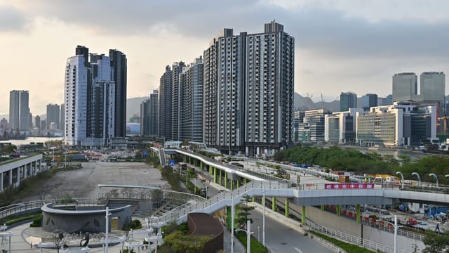 Cityscape view of high-rise buildings and overpass. Modern urban development captured during the day.