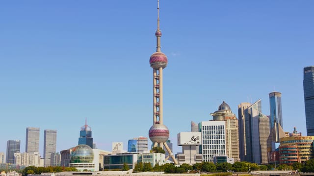 Capture of Shanghai's iconic skyline featuring the Oriental Pearl Tower during a clear day.