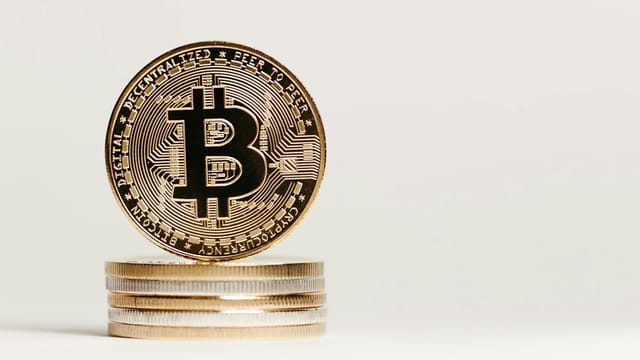 Golden Bitcoin displayed prominently on a white background showcasing cryptocurrency value.
