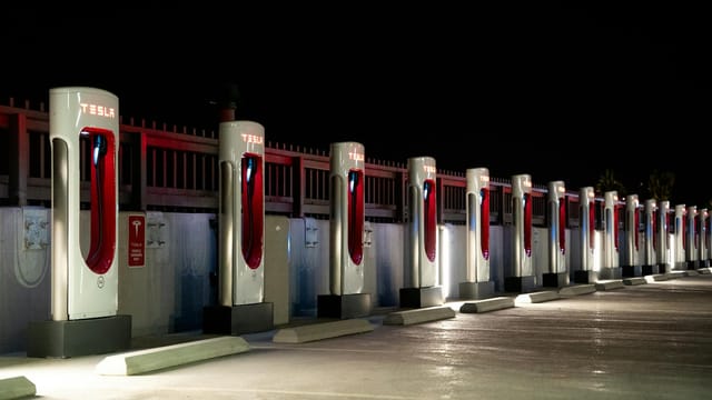 A row of Tesla charging stations illuminated at night in Redlands, CA.