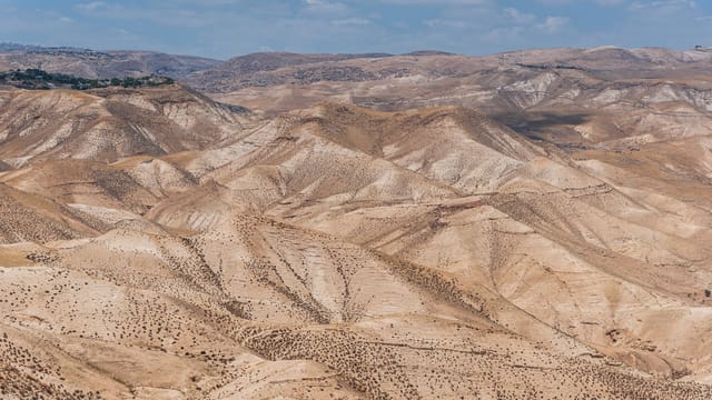 Scenic view of arid desert hills under a clear blue sky in Israel.