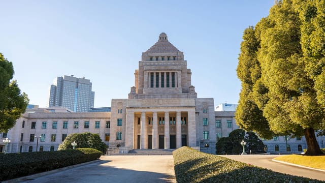 Front view of the National Diet Building in Tokyo on a sunny day, showcasing classic architecture.