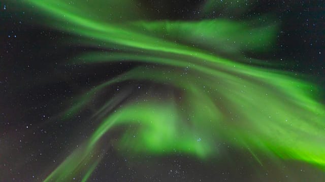 Stunning aurora borealis gracefully dancing in the night sky above Lødingen, Norway.