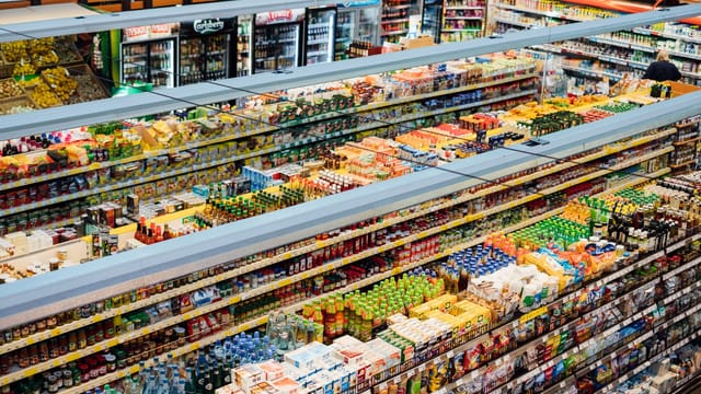 Explore the colorful, fully-stocked shelves of a bustling supermarket from above.