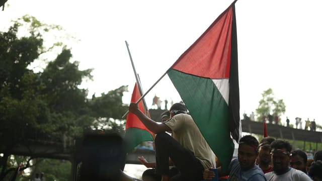 A vibrant public demonstration in Dhaka supporting Gaza with protestors waving flags, capturing solidarity.