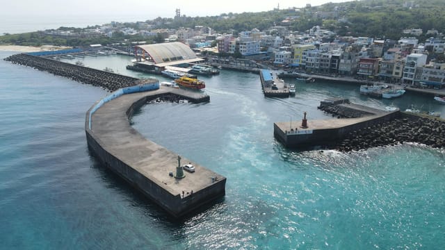 Captivating aerial shot of a bustling coastal harbor with colorful buildings and boats in Taiwan.