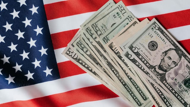 Top view of various dollar banknotes placed on flag of United States of America
