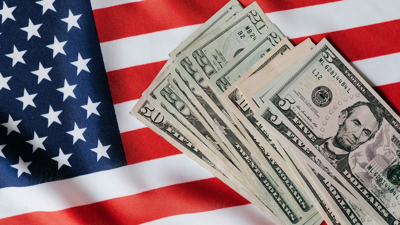 Top view of various dollar banknotes placed on flag of United States of America