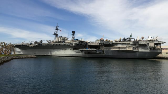USS Midway aircraft carrier docked in San Diego Harbor, showcasing naval history.