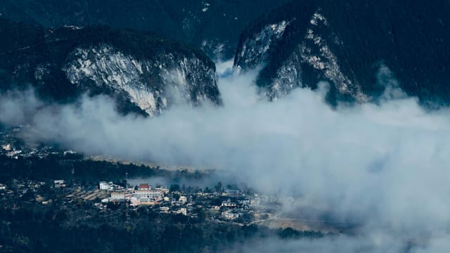 Breathtaking aerial view of Nujiang village nestled in misty Yunnan mountains.