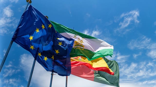 Low angle shot of European Union flags waving against a clear blue sky, symbolizing unity.