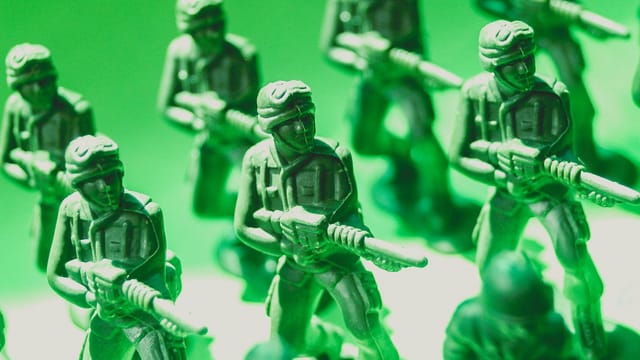 Detailed view of green plastic toy soldiers lined up in formation, symbolizing strategy and teamwork.