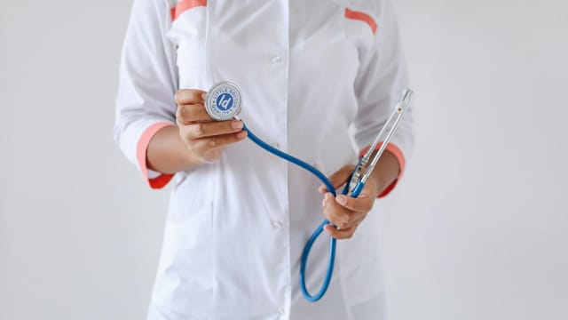 Close-up of a female doctor holding a blue stethoscope, emphasizing healthcare and professionalism.