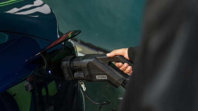 Close-up of an electric vehicle being charged at a station.
