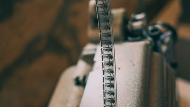 Close-up of a vintage film strip on a projector, showcasing classic cinema.