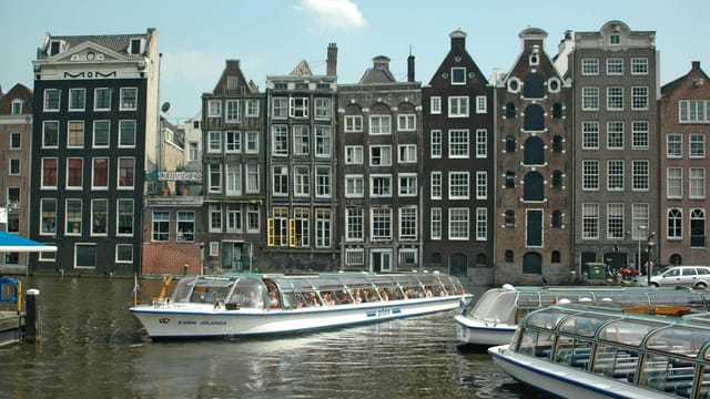 Explore Amsterdam's canals with historic gabled houses and iconic watercrafts.