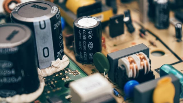 Detailed close-up of capacitors and components on a circuit board, showcasing electronic technology.