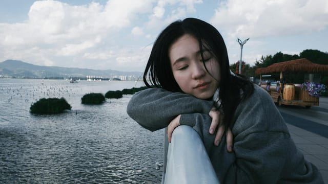 Young woman relaxing peacefully by Dianchi Lake with scenic views in Kunming.