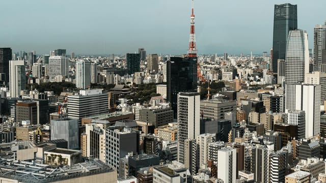 Aerial view of Tokyo's skyline with the Tokyo Tower prominently visible, showcasing modern architecture.