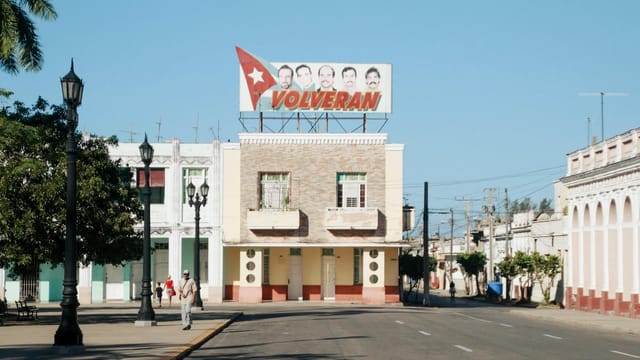 Street view of a charming town with a historical Volveran sign and colonial architecture.