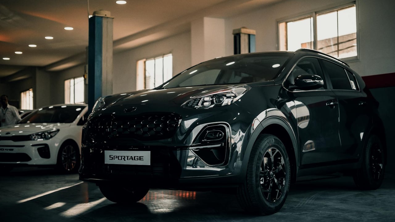 Kia Sportage parked indoors in a stylish garage, showcasing sleek design and glossy finish.