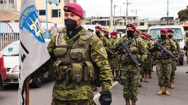 Ecuadorian soldiers in camouflage and berets participating in a parade, showcasing military discipline.