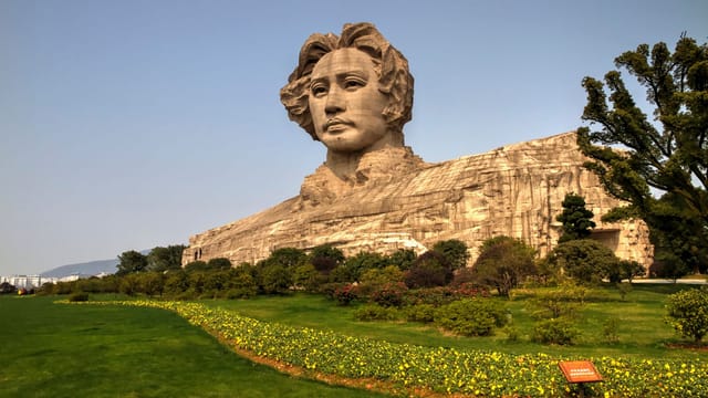 Discover the monumental Mao Zedong statue set amidst lush greenery in Changsha's Orange Isle.