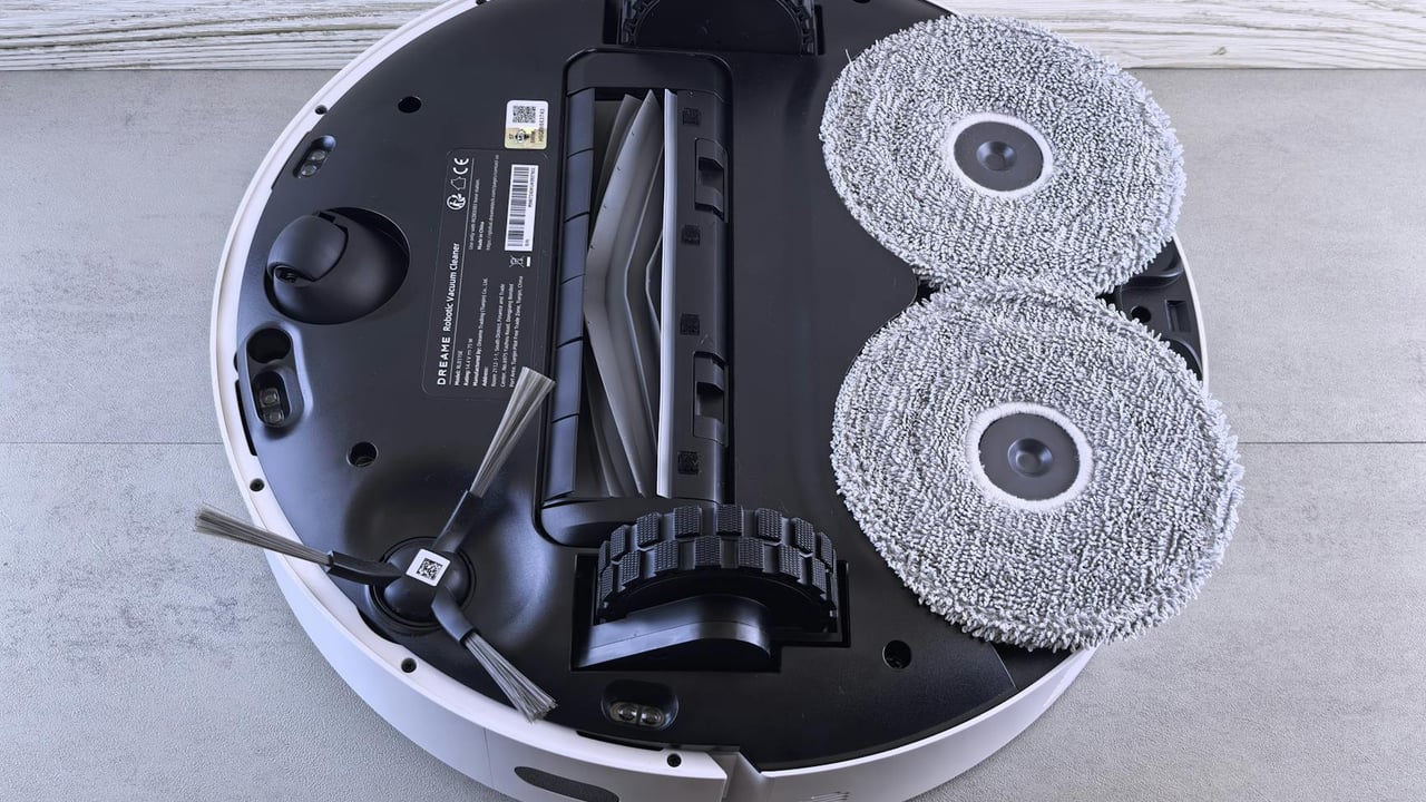 Detailed view of a robotic vacuum cleaner's underside showing brushes and wheels.