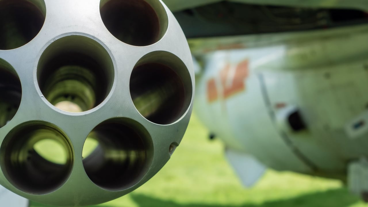 Detailed close-up of an aircraft's gun barrel with blurred background.