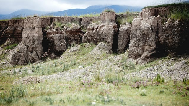 Rich landscape showcasing rugged cliffs and green terrain in rural China.