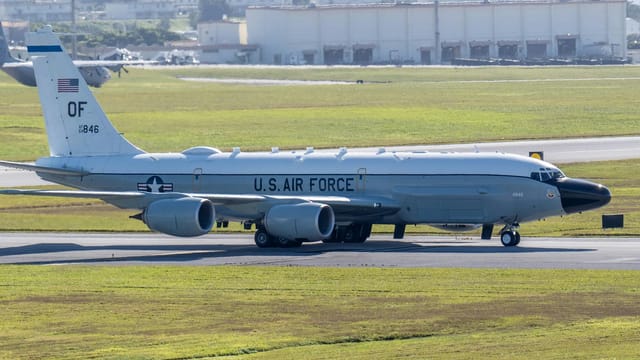 U.S. Air Force reconnaissance aircraft on an airfield runway, ready for takeoff.