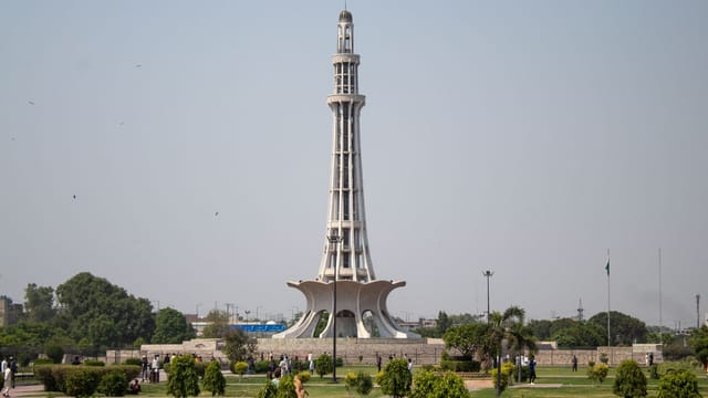 Stunning daytime capture of Minar-e-Pakistan surrounded by lush greenery in Lahore.