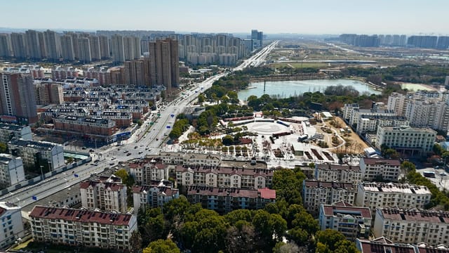 Aerial view of Hefei city skyline featuring residential and urban architecture during daytime.