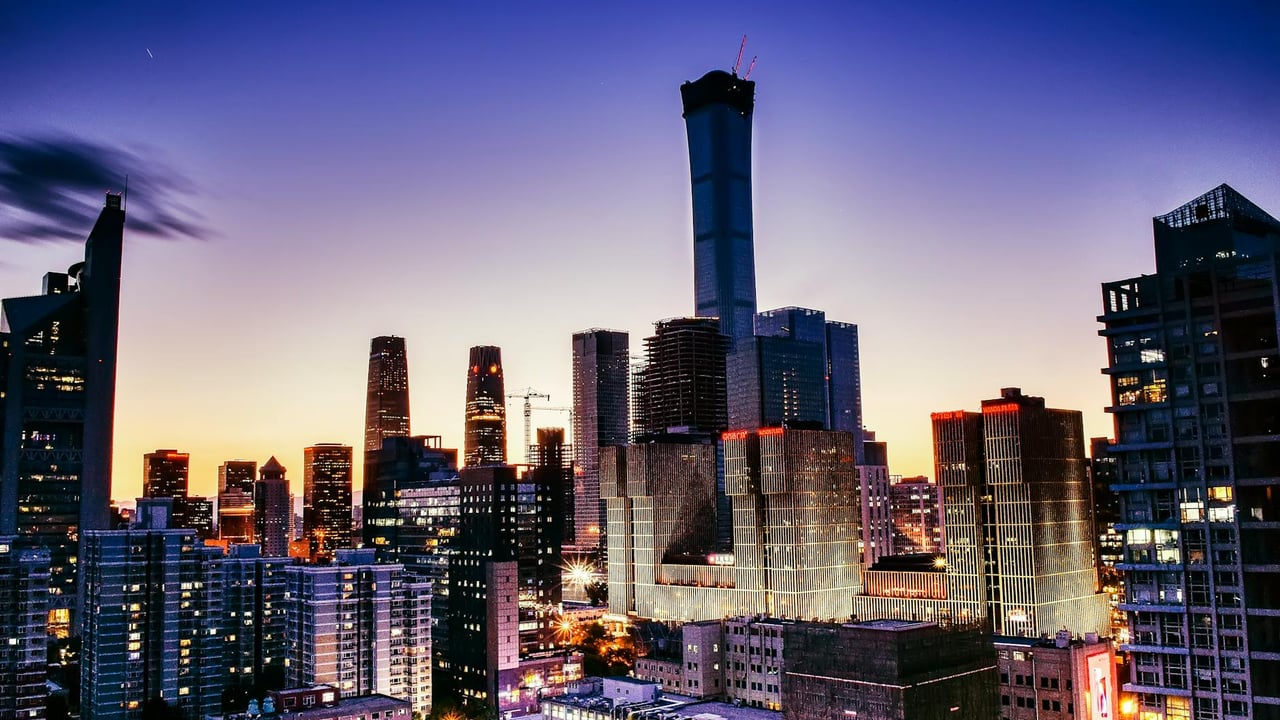 Vibrant cityscape of Beijing's skyline with illuminated skyscrapers at dusk.