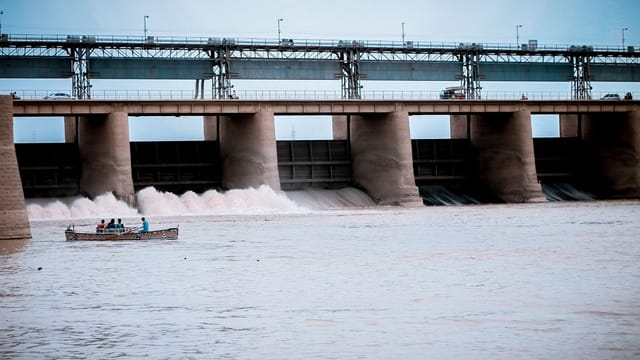 Hydroelectric dam in Jamshoro, Sindh with boat and people on Indus River.
