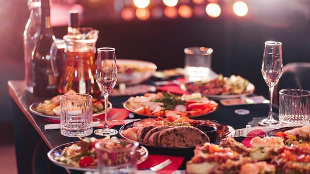 A beautifully set dinner party table with wine, appetizers, and crystal glasses, ready for a celebration.