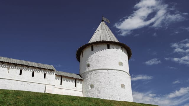 A striking view of the white tower of Kazan Kremlin against a bright blue sky, capturing its historical essence.