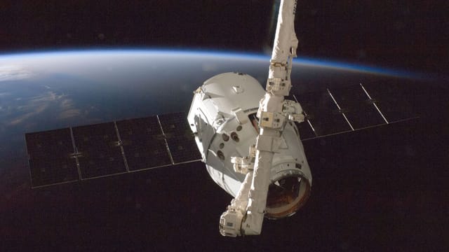 A satellite orbiting Earth with a view of the planet from space.