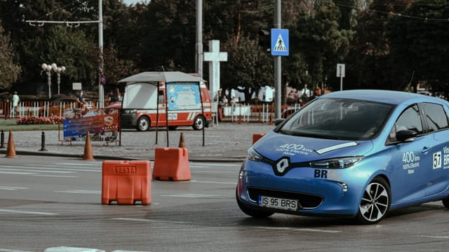 Blue car driving on asphalt race track in city center while racing rally