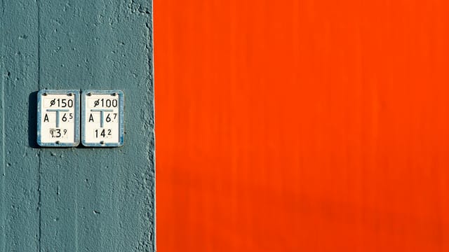 Minimalist wall design featuring a striking contrast between textured blue and vibrant orange surfaces.