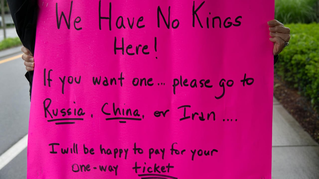 A vibrant protest sign in South Kingstown, Rhode Island, advocating against monarchies with political messaging.