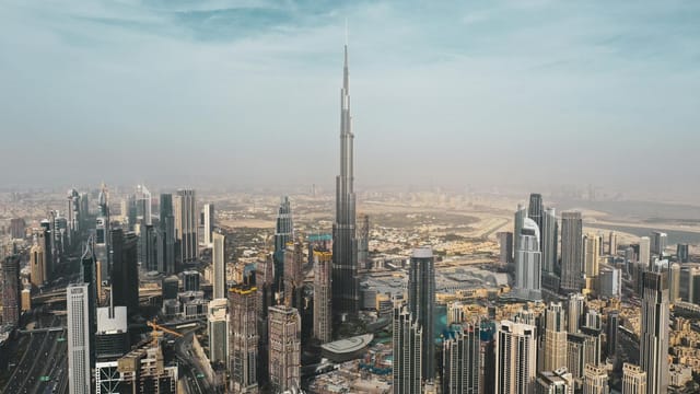 A breathtaking aerial view of Dubai's skyline featuring Burj Khalifa amidst modern skyscrapers under a clear sky.