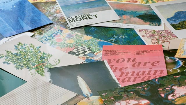 A vibrant collection of various art-related postcards and prints featuring Claude Monet's work.